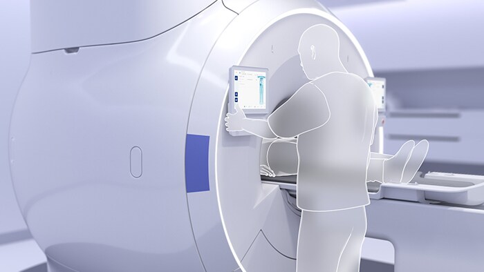 Photo of technologist using an MR imaging touch screen to activate one-touch auto-start