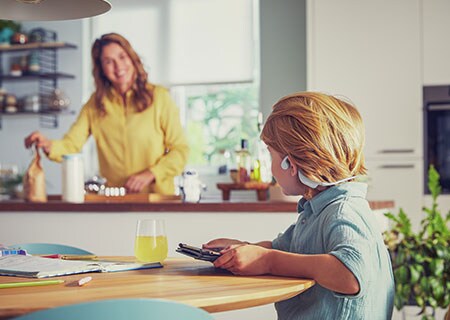 Zēns skatās video, izmantojot Philips atvērtā tipa bezvadu austiņas bērniem