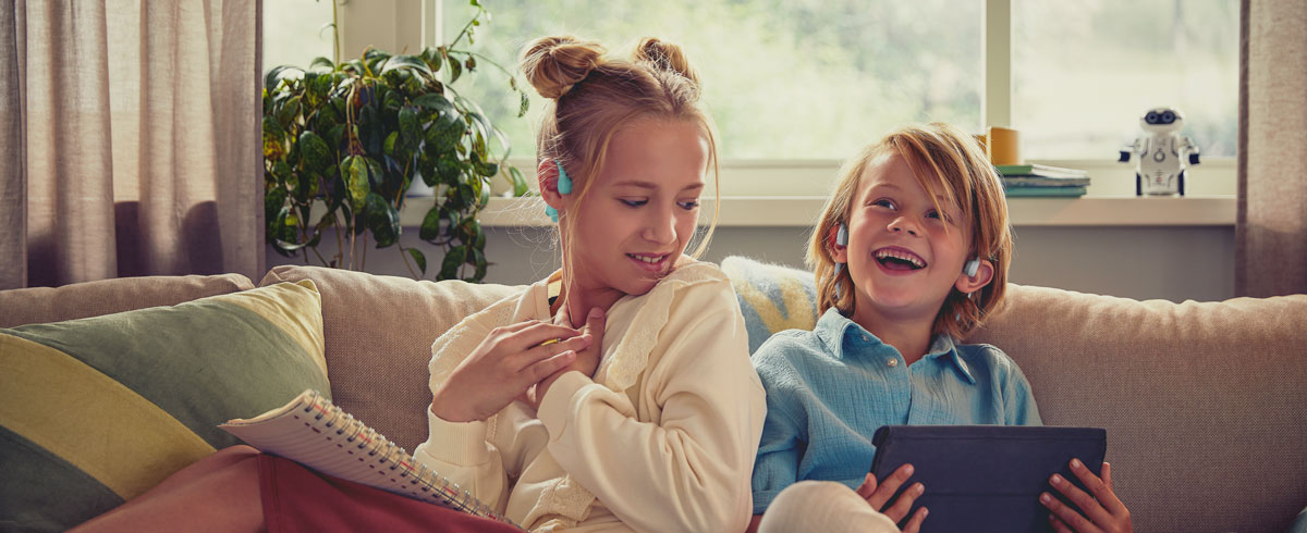 Bērni skatās video, izmantojot Philips atvērtā tipa austiņas bērniem