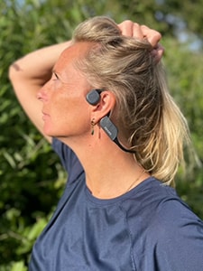 Sieviete ar Philips kaulu vadītspējas tehnoloģijas Bluetooth austiņām