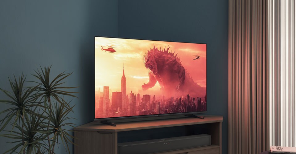 Uz stūra statīva uz Philips televizora tiek rādīta filma “Godzilla”