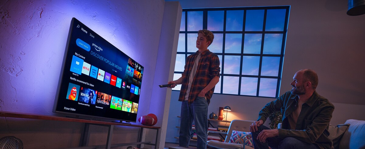 Vīrietis izvēlas lietotni Philips viedtelevizorā