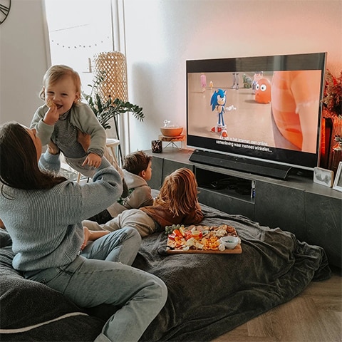 Šeima žiūri Ambilight televizorių